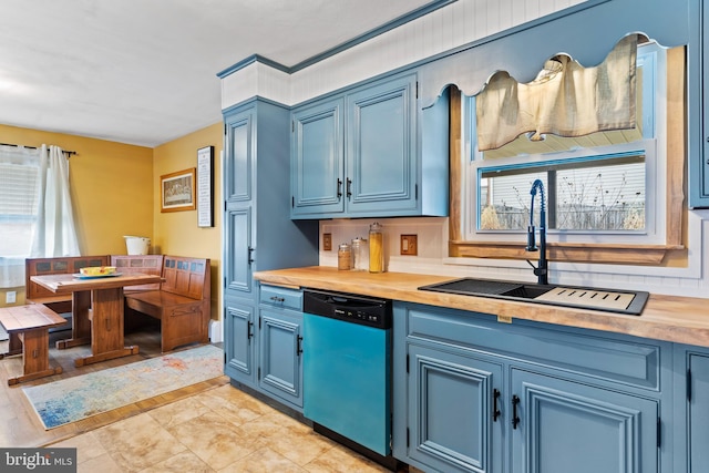 kitchen featuring wood counters, dishwashing machine, blue cabinets, and a sink