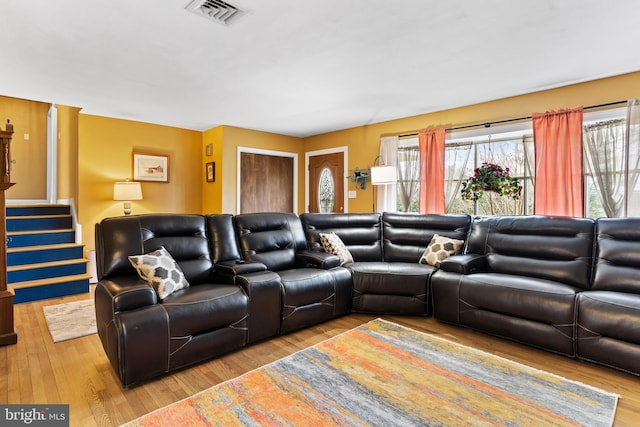 living area featuring visible vents, wood finished floors, and stairs