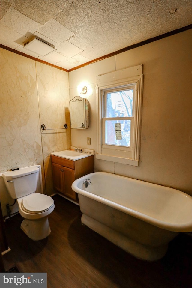 full bathroom featuring vanity, wood finished floors, a soaking tub, ornamental molding, and toilet