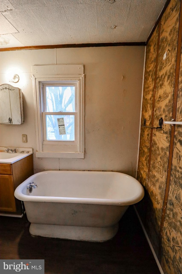 bathroom with a freestanding bath, vanity, and a textured ceiling