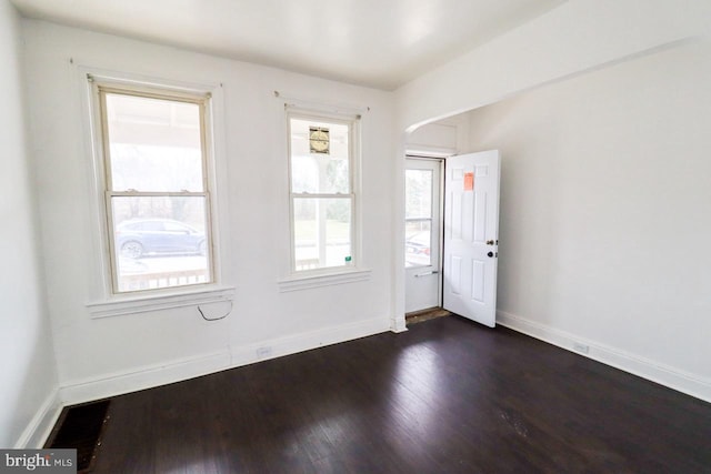 interior space featuring baseboards and dark wood-style flooring