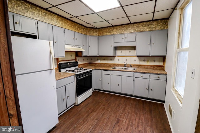 kitchen with gray cabinets, under cabinet range hood, a sink, range with gas stovetop, and freestanding refrigerator