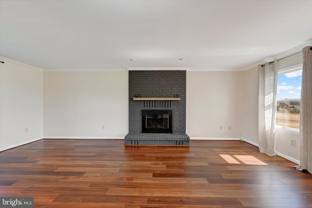 unfurnished living room with ornamental molding and wood finished floors