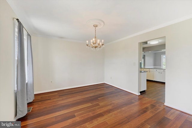 unfurnished dining area with ornamental molding, an inviting chandelier, dark wood-style flooring, and baseboards