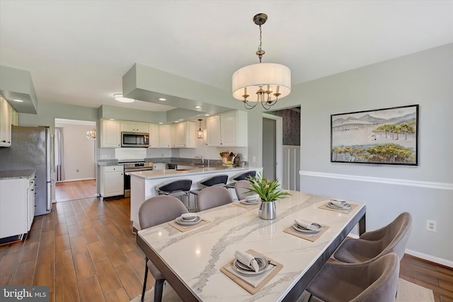 dining area with recessed lighting, baseboards, dark wood-style floors, and a notable chandelier