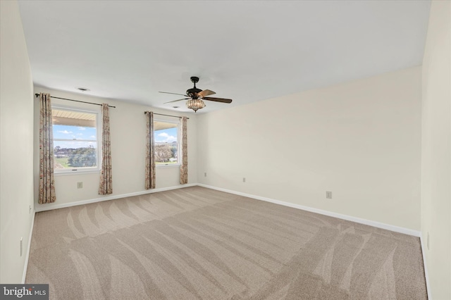 carpeted spare room with baseboards and ceiling fan