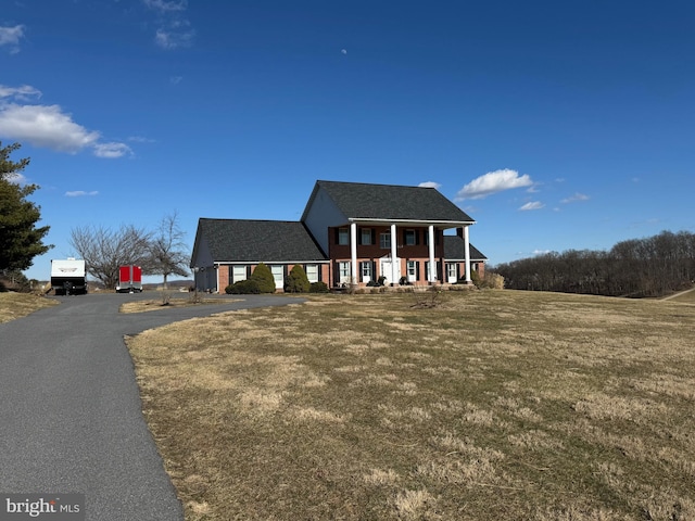 view of front of house featuring covered porch and a front lawn