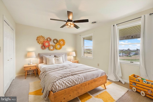 bedroom featuring baseboards, visible vents, and light colored carpet