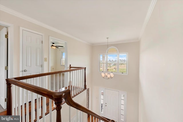 hallway with an inviting chandelier, crown molding, and an upstairs landing