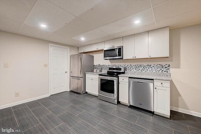 kitchen with white cabinets, baseboards, and appliances with stainless steel finishes