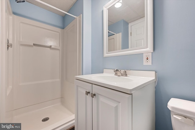 full bath with vanity, toilet, and a stall shower