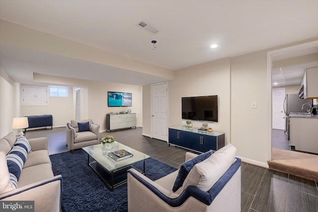 living area with recessed lighting, wood finish floors, visible vents, and baseboards