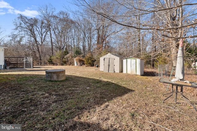 view of yard featuring a deck, an outbuilding, and a shed