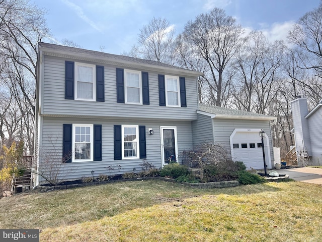 colonial home with a front yard and an attached garage