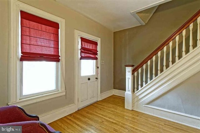 entrance foyer with stairway, baseboards, and wood finished floors