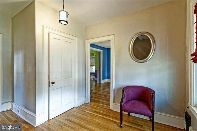 sitting room with baseboards and wood finished floors