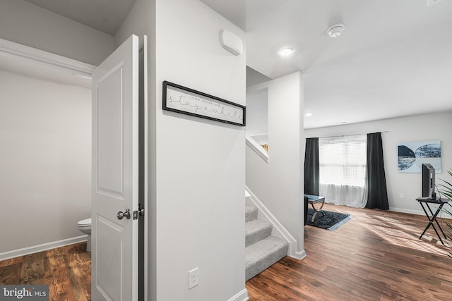 staircase featuring baseboards and wood finished floors