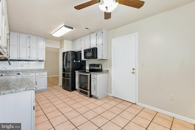 kitchen with tasteful backsplash, visible vents, light tile patterned flooring, black appliances, and a sink