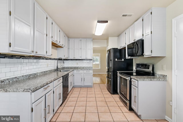 kitchen featuring visible vents, a sink, black appliances, white cabinetry, and backsplash