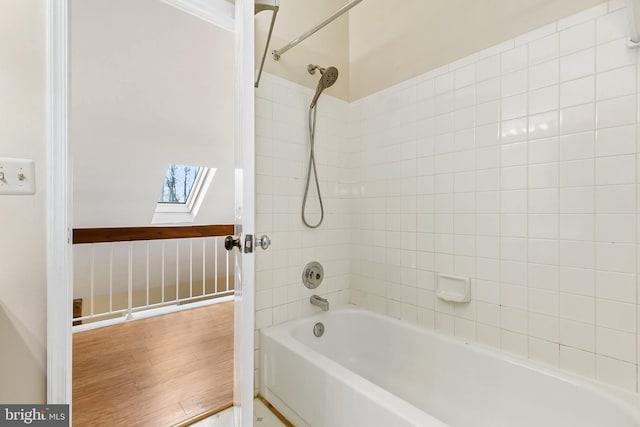 full bathroom featuring tub / shower combination, wood finished floors, and a skylight