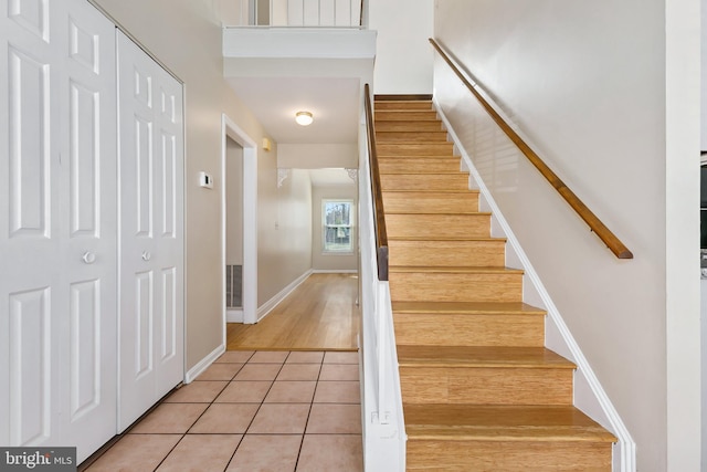 stairs featuring tile patterned flooring and baseboards