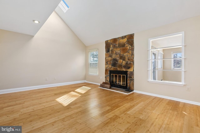 unfurnished living room featuring wood finished floors, a fireplace, baseboards, and high vaulted ceiling