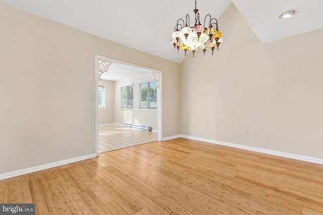 spare room featuring light wood-style flooring, a baseboard heating unit, baseboards, an inviting chandelier, and lofted ceiling