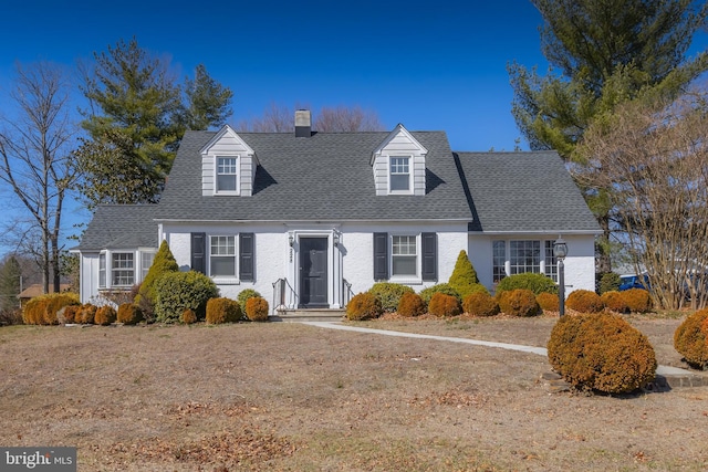 cape cod home with a chimney and roof with shingles