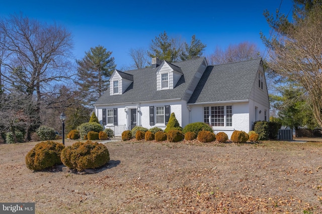 cape cod house featuring central AC and roof with shingles