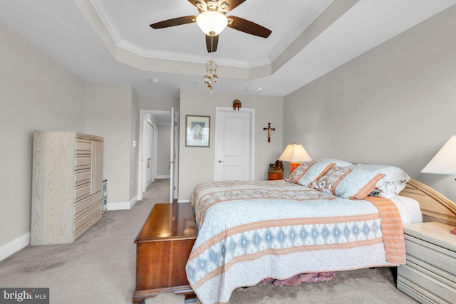 bedroom with a raised ceiling, baseboards, carpet floors, and ornamental molding