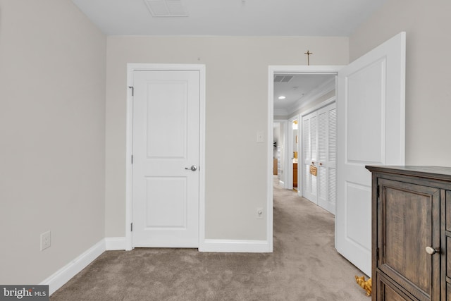 interior space featuring light carpet, visible vents, baseboards, and ornamental molding