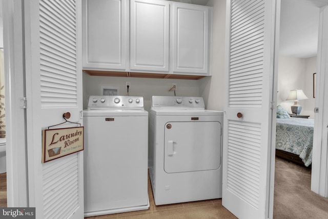 washroom with light carpet, cabinet space, and washer and clothes dryer