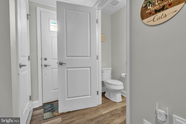 bathroom with toilet, wood finished floors, visible vents, and baseboards