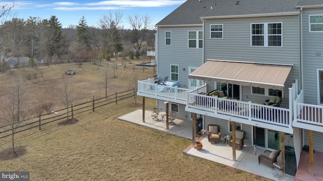 rear view of property with fence, a lawn, and a patio area