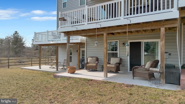 exterior space featuring a patio area, a wooden deck, a yard, and fence