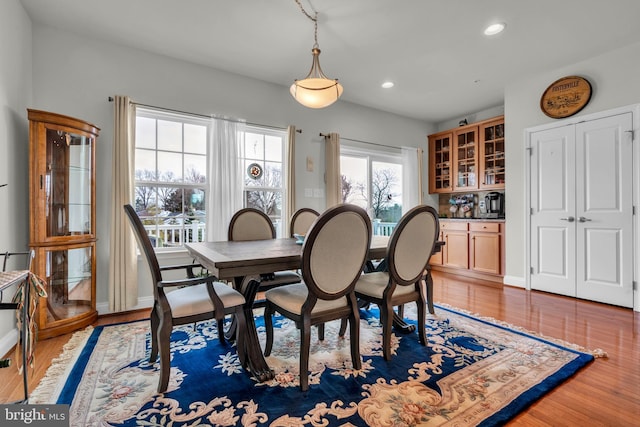 dining room with light wood finished floors, recessed lighting, and baseboards