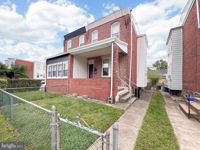 townhome / multi-family property with fence private yard, a gate, brick siding, and a front yard