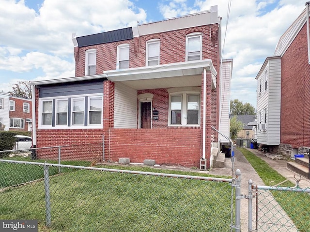 view of front of house featuring fence private yard, brick siding, and a front yard