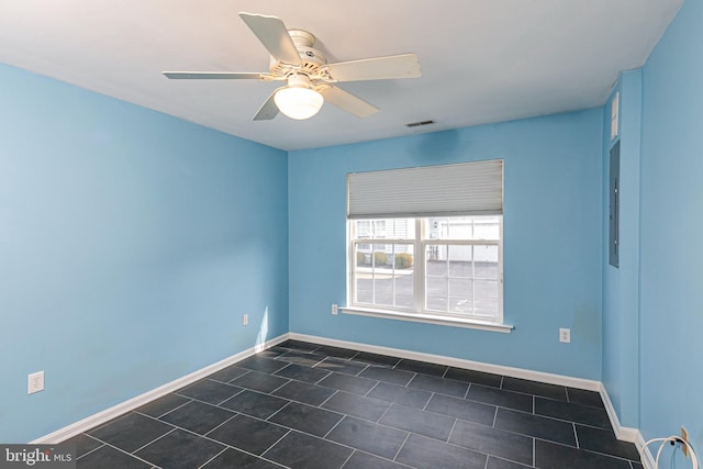 spare room featuring visible vents, a ceiling fan, and baseboards