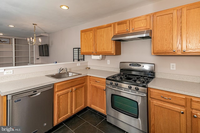 kitchen with under cabinet range hood, a peninsula, a notable chandelier, stainless steel appliances, and a sink