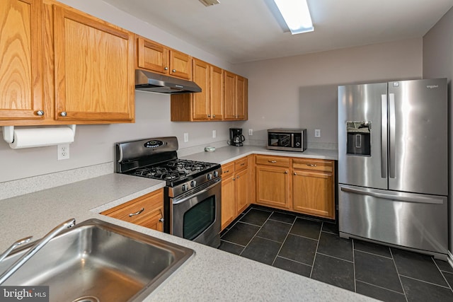 kitchen featuring under cabinet range hood, appliances with stainless steel finishes, light countertops, and a sink