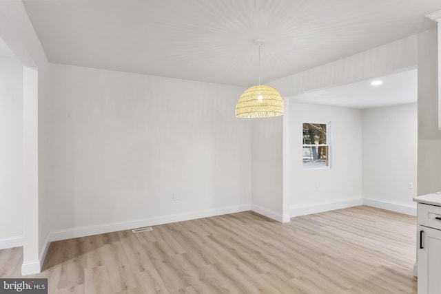 unfurnished dining area with baseboards, visible vents, and light wood-style floors