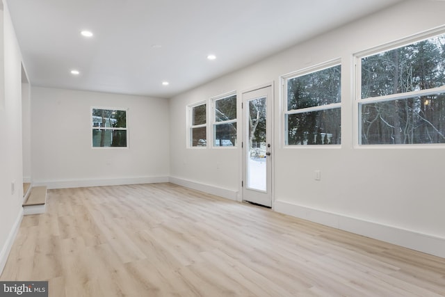 empty room featuring baseboards, wood finished floors, and recessed lighting