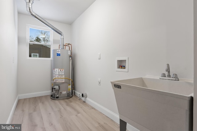 laundry area featuring laundry area, a sink, hookup for a washing machine, water heater, and electric dryer hookup