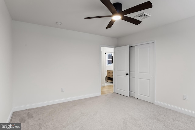 unfurnished bedroom with light carpet, baseboards, visible vents, and a closet