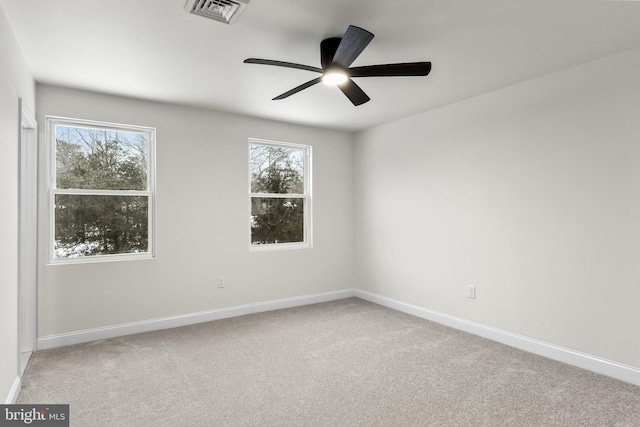 unfurnished room featuring a ceiling fan, carpet, visible vents, and baseboards