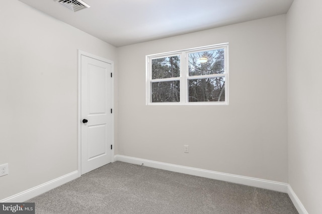 carpeted spare room with visible vents and baseboards