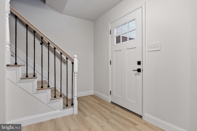 entrance foyer with stairs, baseboards, and wood finished floors