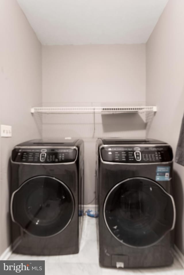 washroom featuring laundry area, washer and clothes dryer, and baseboards