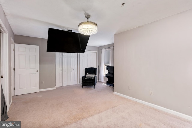 living area featuring baseboards and light colored carpet